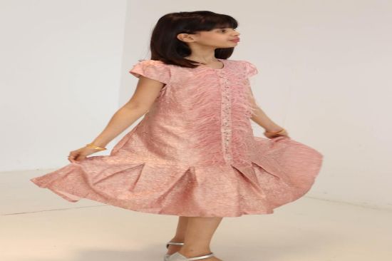 صورة فستان لحمي مع الؤلؤ والريش في نص الفستان